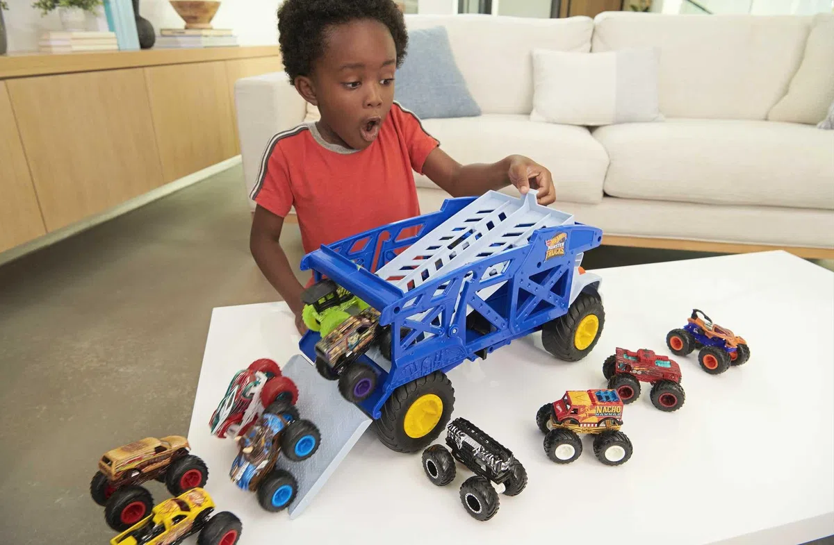 Hot Wheels - Monster Trucks Rino-Trasportatore di auto giocattolo, può contenere 12 Monster Trucks in scala 1:64, con rampa di lancio, Giocattolo per Bambini 3+ Anni, HFB13
